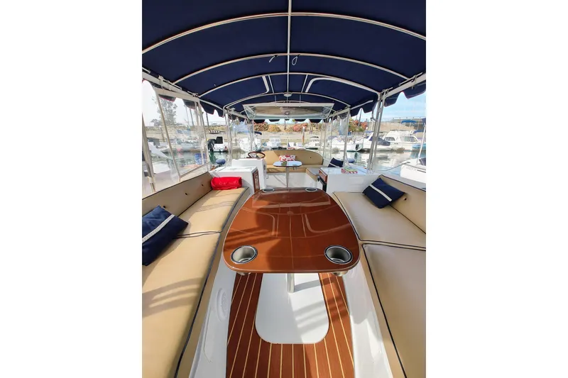 Slide: The Image of Interior of 2022 Duffy Bay Island boat with cushioned seating and wooden table. - 2
