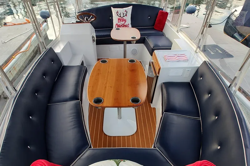Slide: The Image of 2022 Duffy Bay Island boat interior with navy seating, wooden tables, and festive decor. - 5