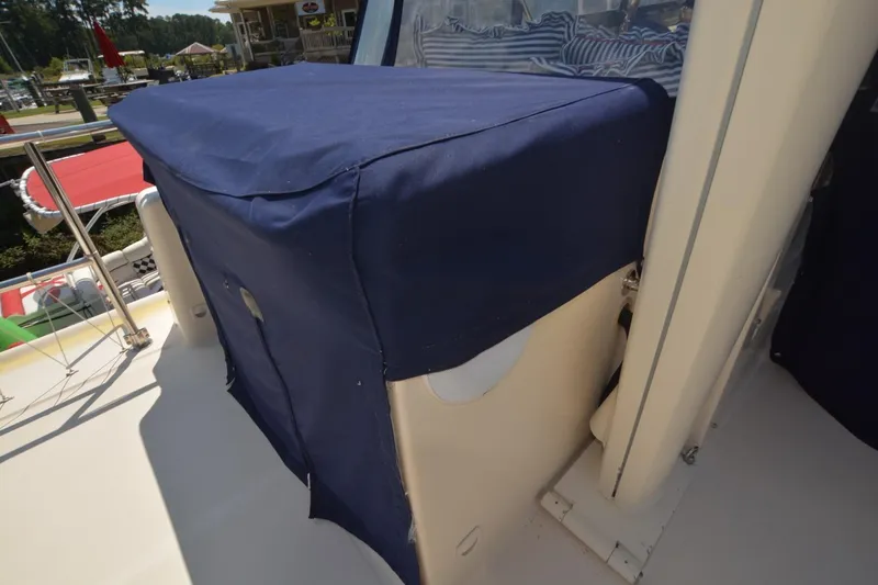 Slide: The Image of 2004 Mainship 400 Trawler with blue canvas cover on deck, docked at marina. - 23