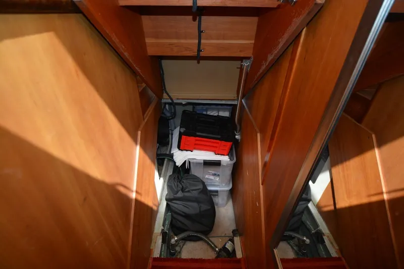 Slide: The Image of Storage area inside 2004 Mainship 400 Trawler with wooden panels and organized containers. - 24