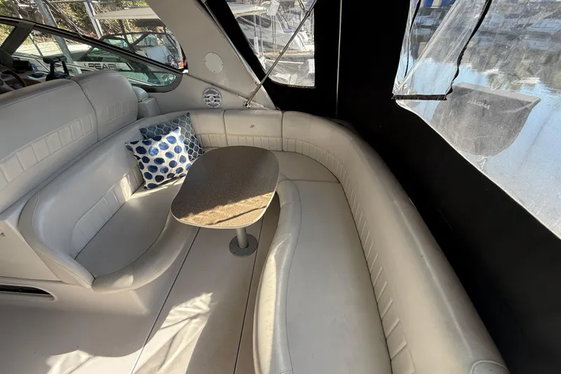 Slide: The Image of 2002 Four Winns 328 Vista boat interior with curved seating and table. - 12