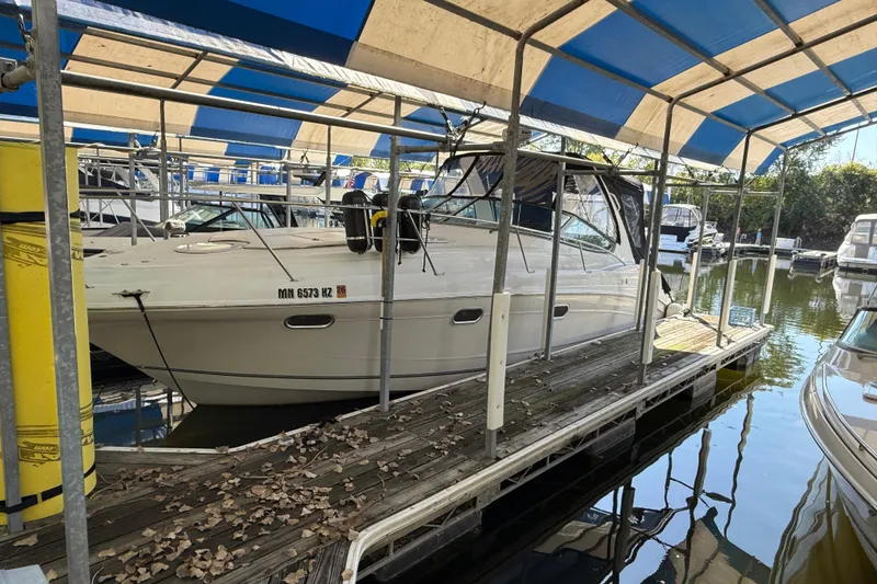 Slide: The Image of 2002 Four Winns 328 Vista boat docked under a blue and white canopy. - 2