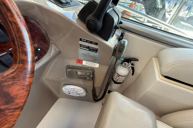Slide: The Image of 2002 Four Winns 328 Vista boat cockpit with steering wheel, controls, and fire extinguisher. - 28