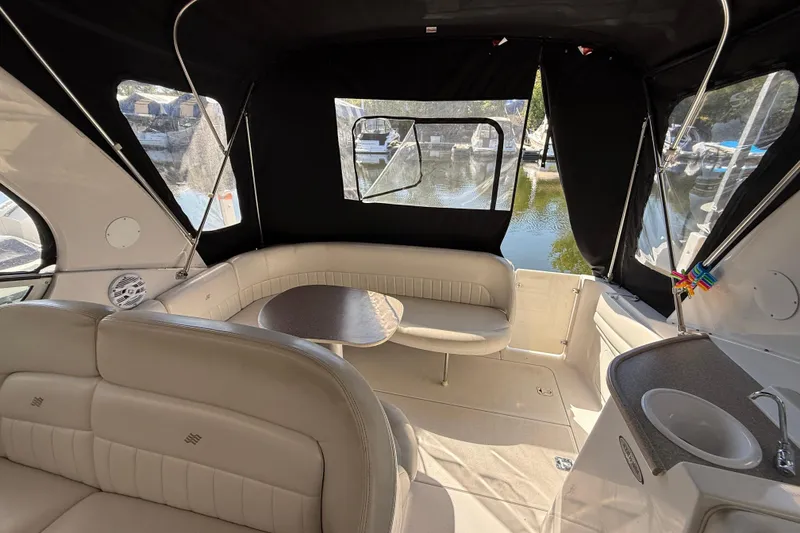 Slide: The Image of Interior of 2002 Four Winns 328 Vista boat with seating and table, docked by water. - 30