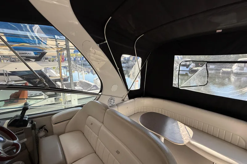 Slide: The Image of Interior of 2002 Four Winns 328 Vista boat with leather seating and table, docked at marina. - 31
