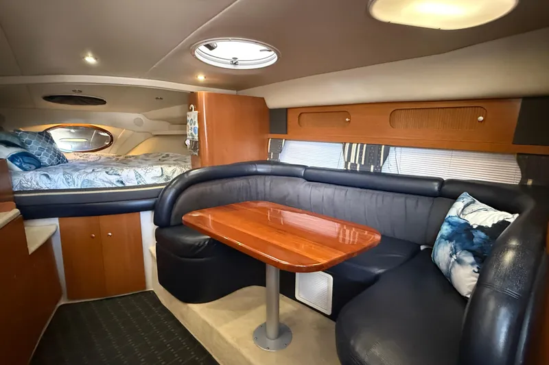 Slide: The Image of 2002 Four Winns 328 Vista cabin interior with cozy seating and wooden table. - 32