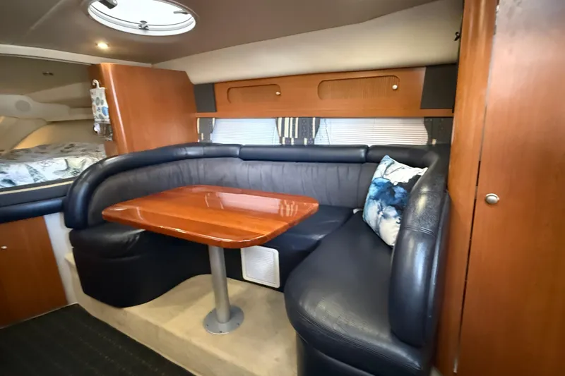 Slide: The Image of 2002 Four Winns 328 Vista cabin interior with leather seating and wooden table. - 33