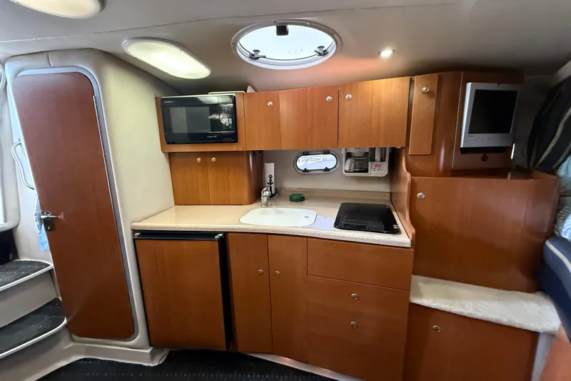 Slide: The Image of 2002 Four Winns 328 Vista boat interior kitchen with wood cabinets, microwave, and sink. - 41