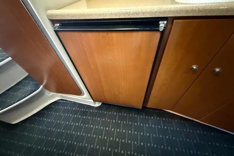 Slide: The Image of 2002 Four Winns 328 Vista interior with wood cabinetry and compact fridge. - 45