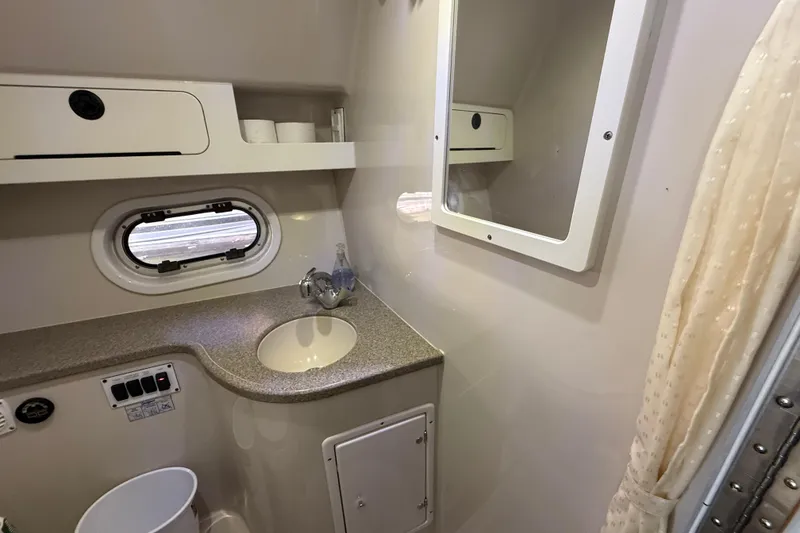 Slide: The Image of 2002 Four Winns 328 Vista boat bathroom with sink, mirror, and storage shelves. - 49