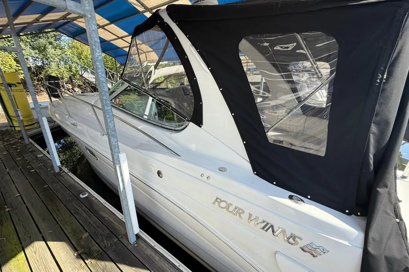 Slide: The Image of 2002 Four Winns 328 Vista boat docked under a blue canopy. - 5