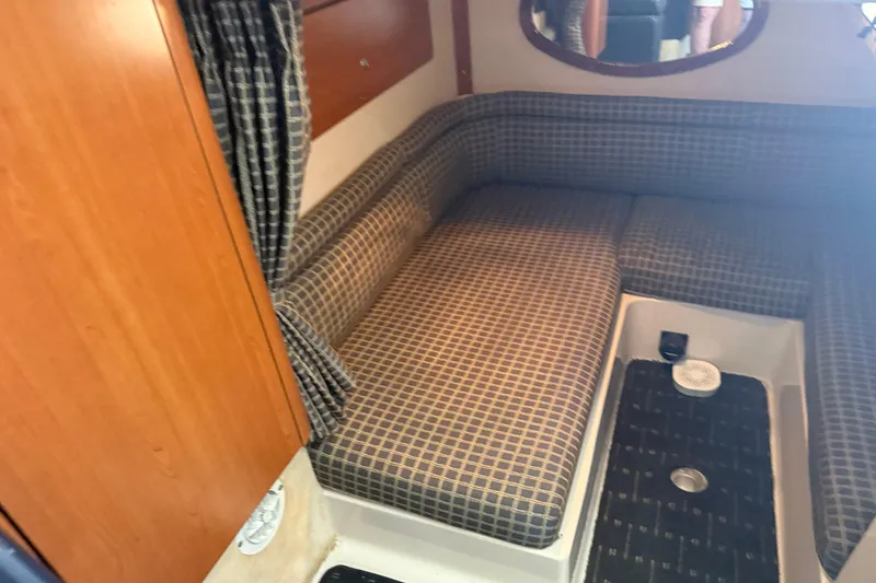 Slide: The Image of 2002 Four Winns 328 Vista cabin interior with plaid seating and wooden accents. - 50