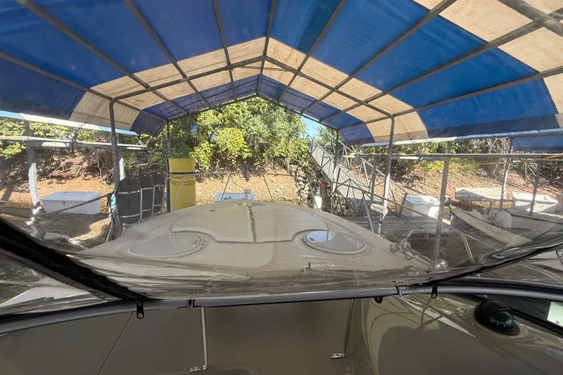 Slide: The Image of 2002 Four Winns 328 Vista boat under blue canopy, docked near trees. - 6