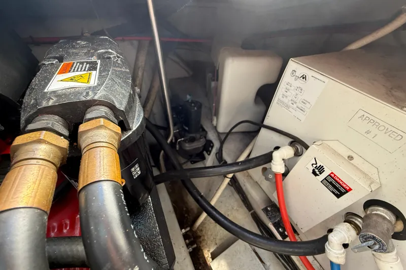 Slide: The Image of Engine compartment of a 2002 Four Winns 328 Vista boat, showing mechanical components and warning labels. - 64