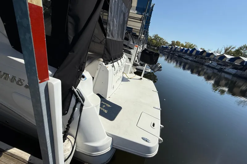 Slide: The Image of 2002 Four Winns 328 Vista boat docked at a marina, calm water reflecting surroundings. - 8
