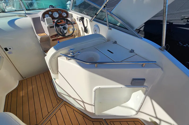 Slide: The Image of 2004 Rinker 270 Fiesta Vee boat interior with steering wheel and wooden flooring. - 11