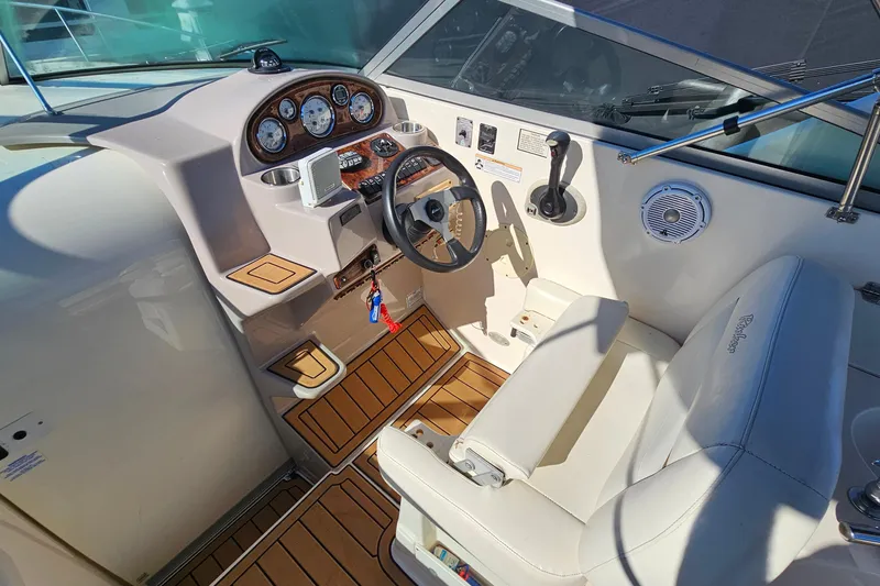 Slide: The Image of 2004 Rinker 270 Fiesta Vee boat cockpit with steering wheel and control panel. - 12