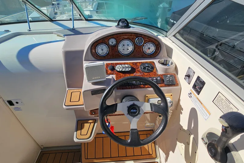 Slide: The Image of 2004 Rinker 270 Fiesta Vee boat dashboard with steering wheel and control panel. - 13