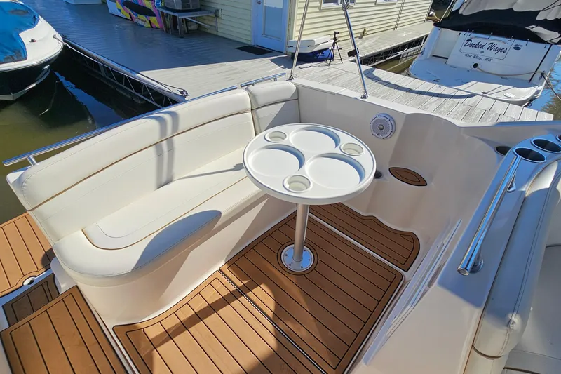 Slide: The Image of 2004 Rinker 270 Fiesta Vee boat interior with seating and table, docked at marina. - 15