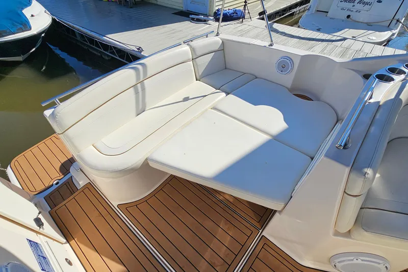 Slide: The Image of 2004 Rinker 270 Fiesta Vee boat interior with white seating and wood flooring. - 16