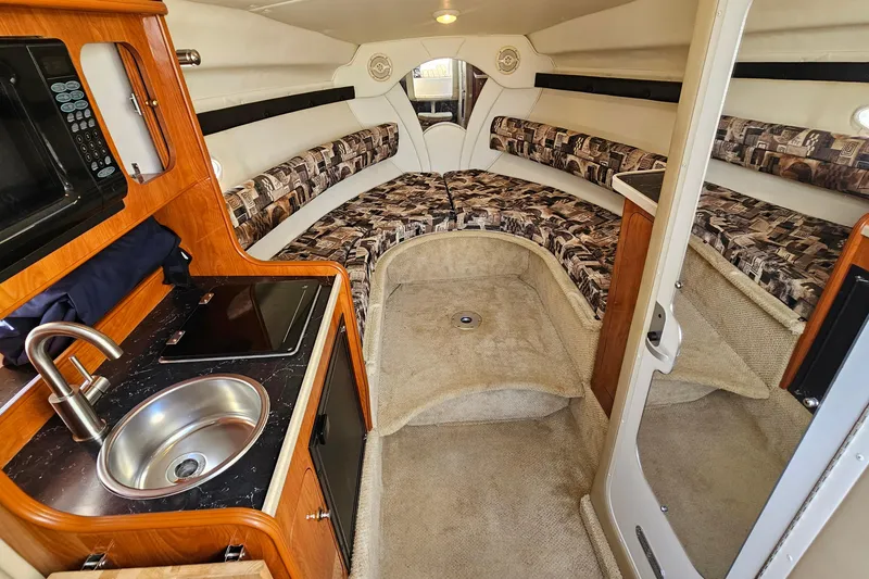 Slide: The Image of Interior of 2004 Rinker 270 Fiesta Vee boat with kitchenette and seating area. - 17