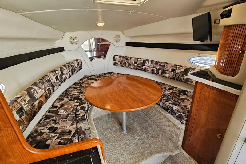 Slide: The Image of 2004 Rinker 270 Fiesta Vee cabin interior with seating, table, and TV. - 18