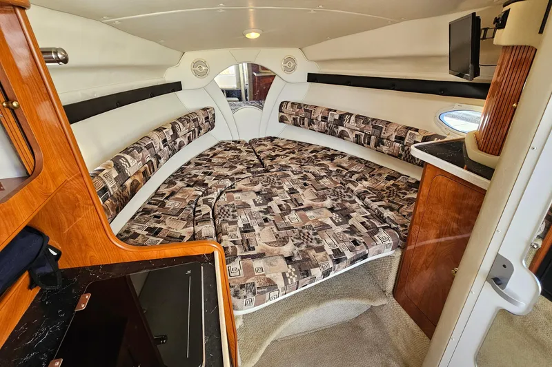 Slide: The Image of Interior of 2004 Rinker 270 Fiesta Vee boat with cozy sleeping area and wood accents. - 19