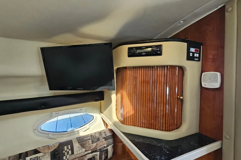 Slide: The Image of 2004 Rinker 270 Fiesta Vee cabin interior with TV and audio system. - 22
