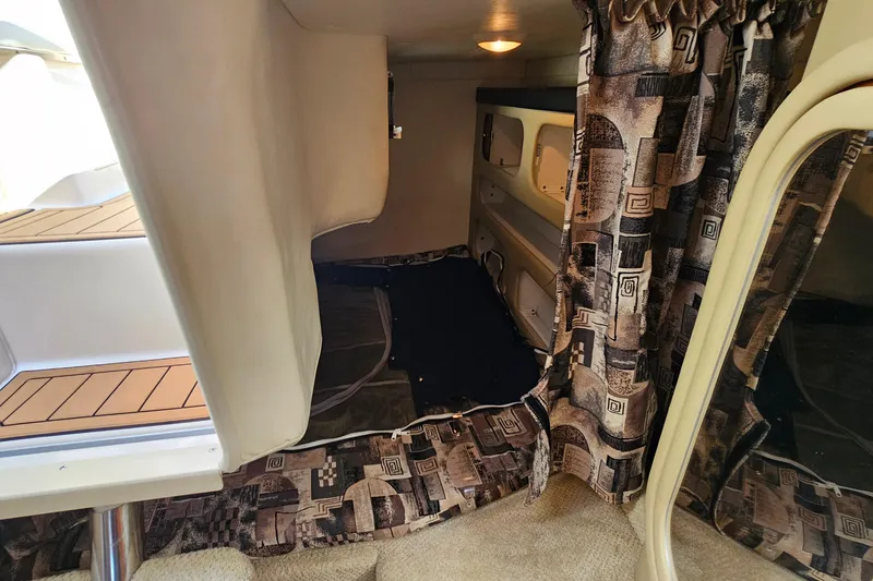 Slide: The Image of Interior cabin of 2004 Rinker 270 Fiesta Vee boat with patterned curtains. - 23