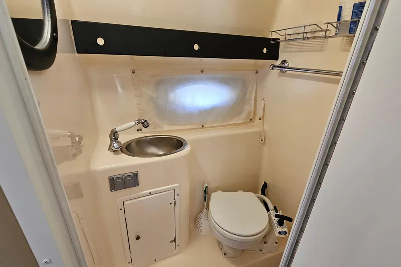 Slide: The Image of 2004 Rinker 270 Fiesta Vee boat bathroom with sink, toilet, and storage. - 25