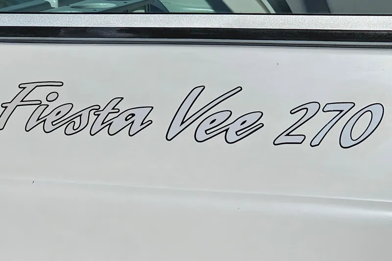 Slide: The Image of 2004 Rinker 270 Fiesta Vee boat logo on white surface. - 28