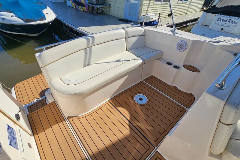 Slide: The Image of 2004 Rinker 270 Fiesta Vee boat interior with white seating and teak flooring. - 8