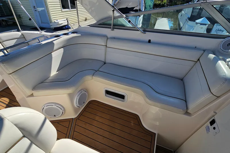 Slide: The Image of 2004 Rinker 270 Fiesta Vee boat interior with white seating and wood flooring. - 9
