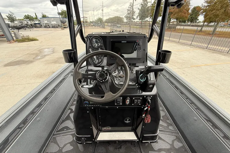 Slide: The Image of 2023 Excel 220 Bay Pro boat console with steering wheel and navigation controls. - 14