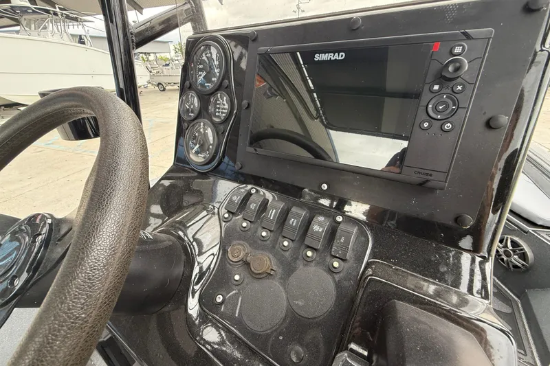 Slide: The Image of 2023 Excel 220 Bay Pro boat dashboard with Simrad display and control panel. - 15