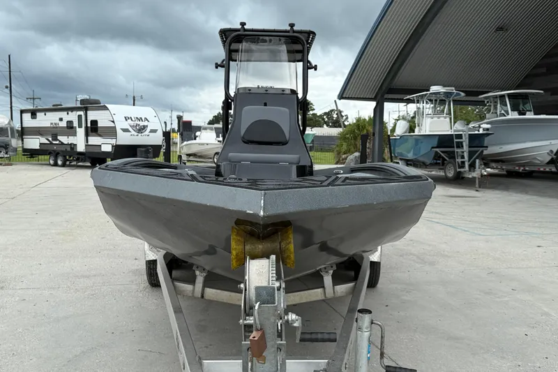 Slide: The Image of 2023 Excel 220 Bay Pro boat on trailer, parked outdoors under cloudy sky. - 3