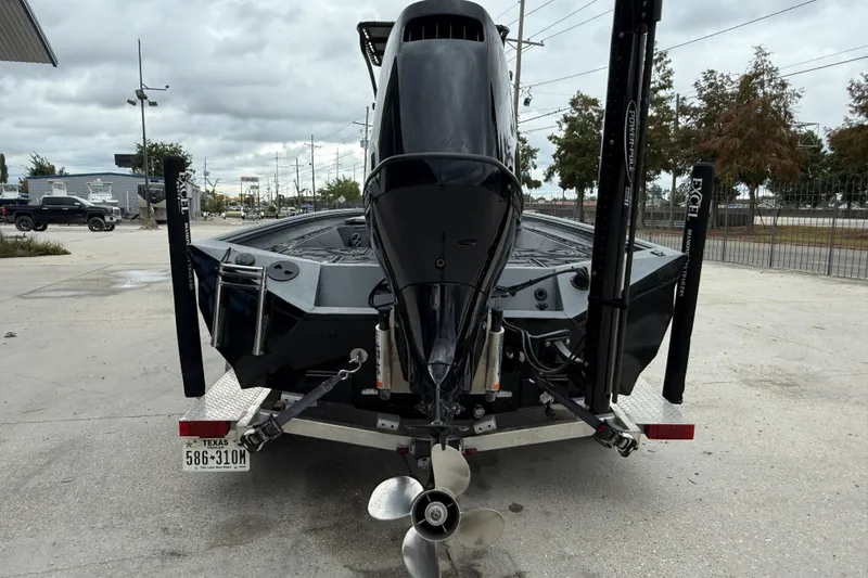 Slide: The Image of 2023 Excel 220 Bay Pro boat rear view with motor and trailer in parking lot. - 6