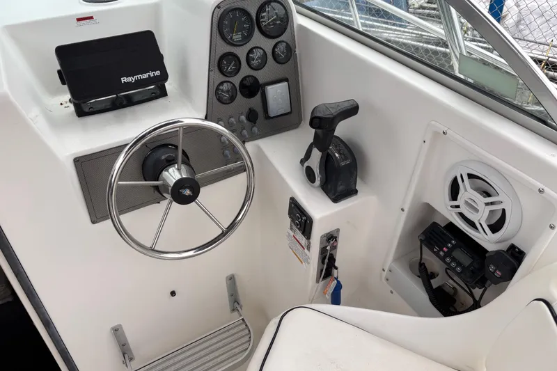 Slide: The Image of 1999 Wellcraft 22 Coastal Walkaround O/B helm with steering wheel, gauges, and Raymarine equipment. - 11