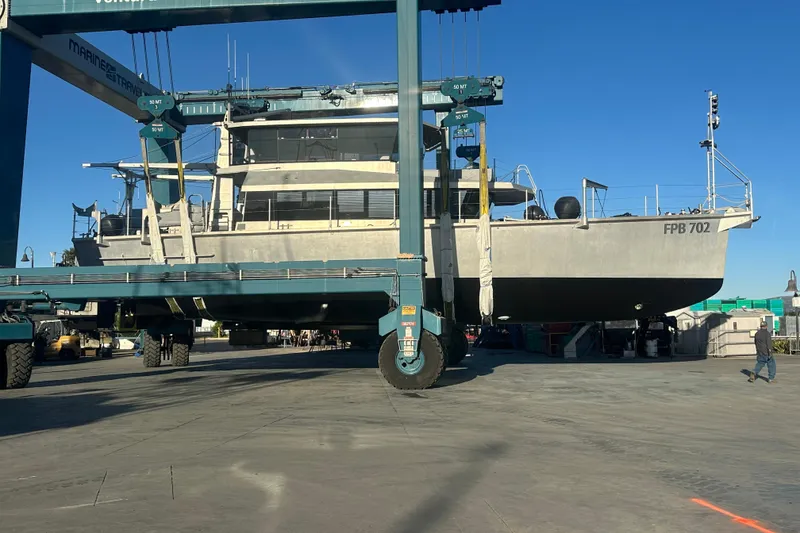 Slide: The Image of 2019 Circa Marine FPB 70 yacht in dry dock, supported by a large marine travel lift. - 2