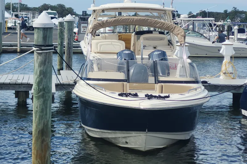 Slide: The Image of 2022 Scout 215 Dorado boat docked at marina, featuring dual engines and sleek design. - 2