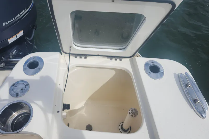 Slide: The Image of 2022 Scout 215 Dorado boat with open storage compartment and visible four-stroke engine. - 21