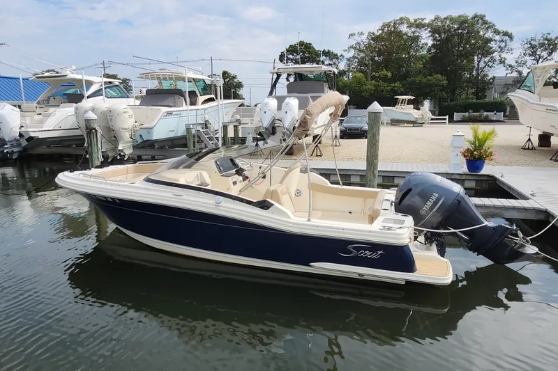 Slide: The Image of 2022 Scout 215 Dorado boat docked, featuring a Yamaha outboard motor. - 6