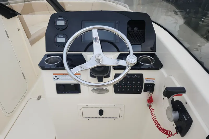 Slide: The Image of 2022 Scout 215 Dorado boat dashboard with steering wheel and control panel. - 7