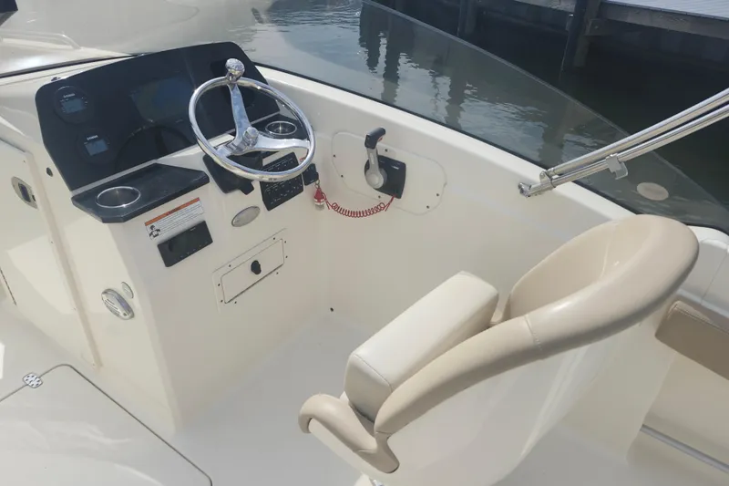 Slide: The Image of 2022 Scout 215 Dorado boat helm with steering wheel and control panel. - 8