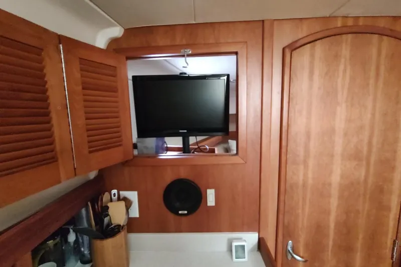 Slide: The Image of Interior of 2003 Mainship 34 PILOT with wooden cabinetry and mounted TV. - 13