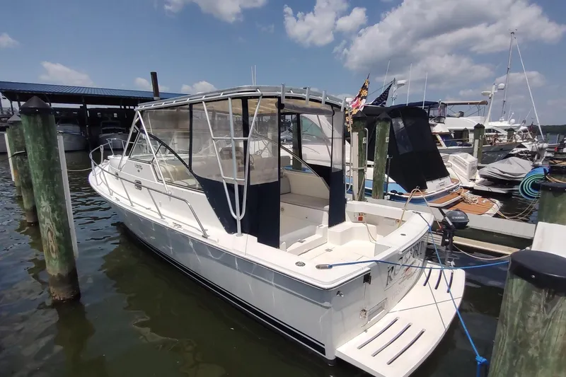 Slide: The Image of 2003 Mainship 34 PILOT boat docked at marina under clear skies. - 2