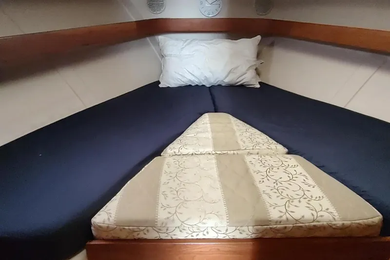 Slide: The Image of Cozy cabin bed in 2003 Mainship 34 PILOT boat, featuring blue and patterned bedding. - 21