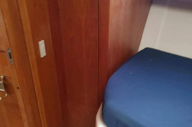 Slide: The Image of Interior cabin of 2003 Mainship 34 PILOT with wooden paneling and blue bedding. - 22