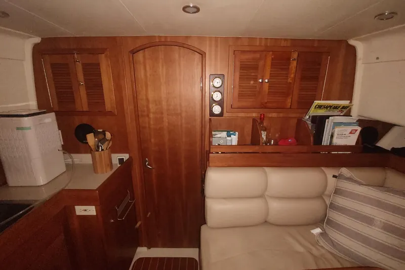 Slide: The Image of Interior of 2003 Mainship 34 PILOT with wooden cabinetry and cozy seating area. - 24