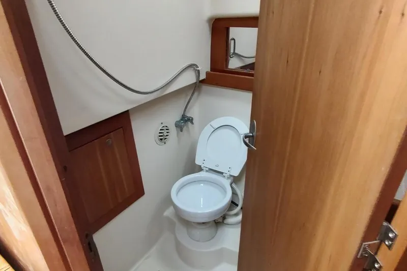 Slide: The Image of 2003 Mainship 34 PILOT boat bathroom with toilet and showerhead. - 34
